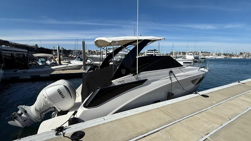 Slide: The Image of 2025 Regal 26 XO boat docked with Yamaha outboard motor, sunny marina setting. - 12
