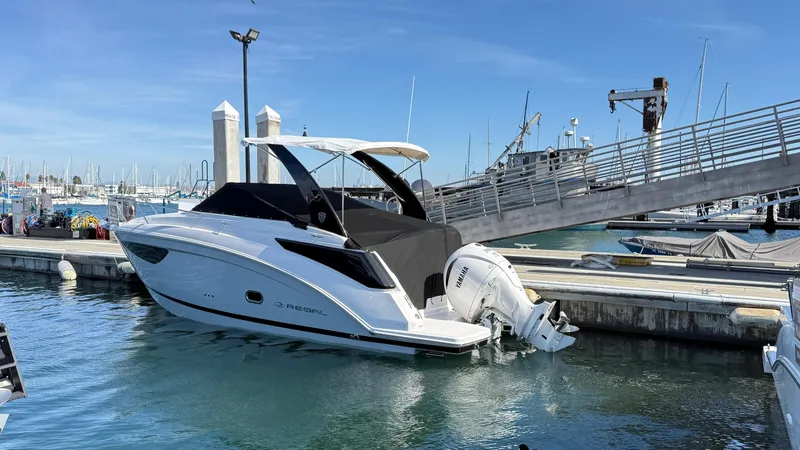 Slide: The Image of 2025 Regal 26 XO boat docked in marina, featuring sleek design and outboard motor. - 16