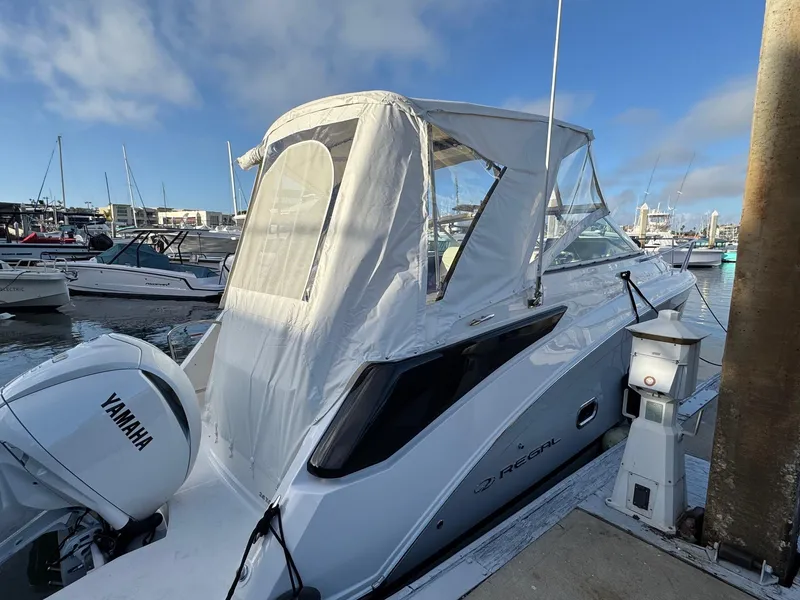 Slide: The Image of 2025 Regal 26 XO boat docked, featuring a Yamaha outboard motor and white canopy. - 19