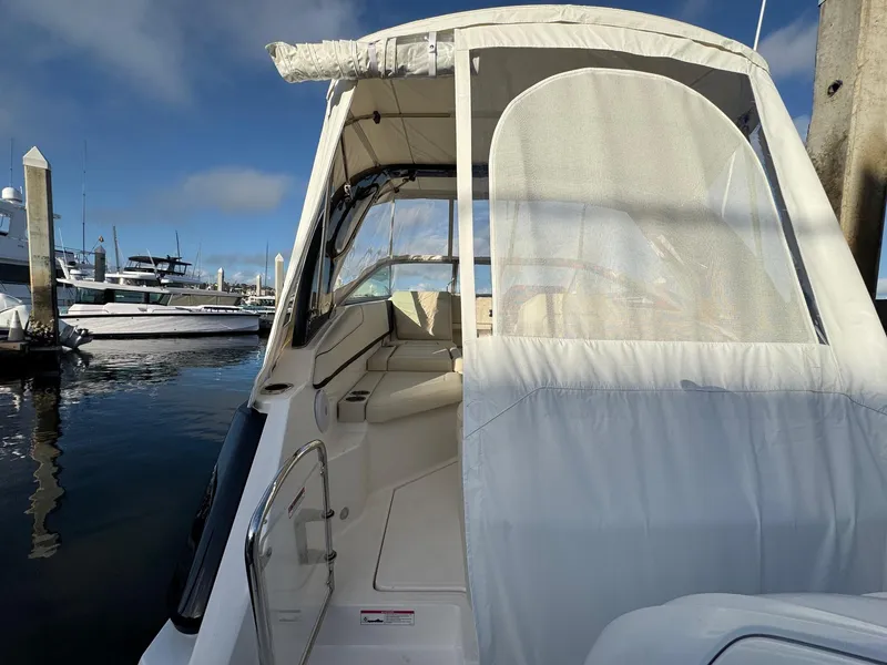 Slide: The Image of 2025 Regal 26 XO boat docked, featuring a covered seating area and sleek design. - 21