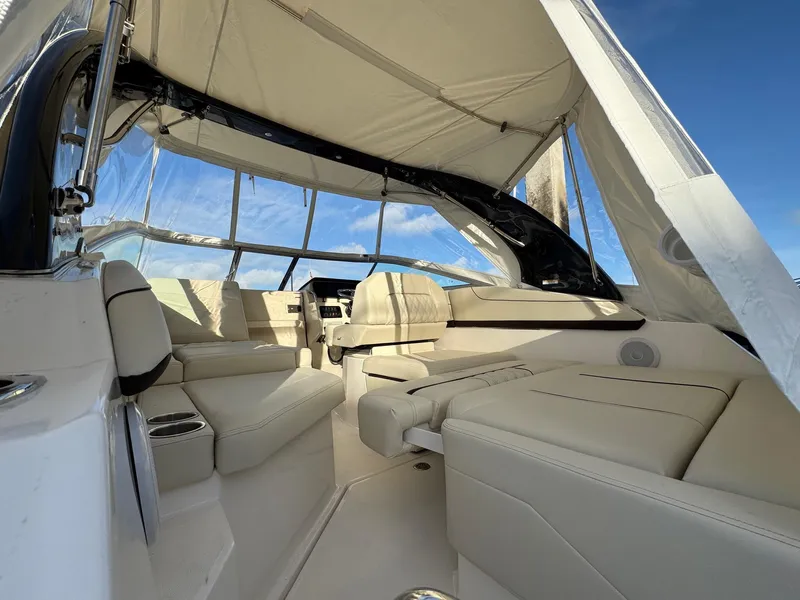Slide: The Image of 2025 Regal 26 XO boat interior with beige seating and canopy under blue sky. - 22