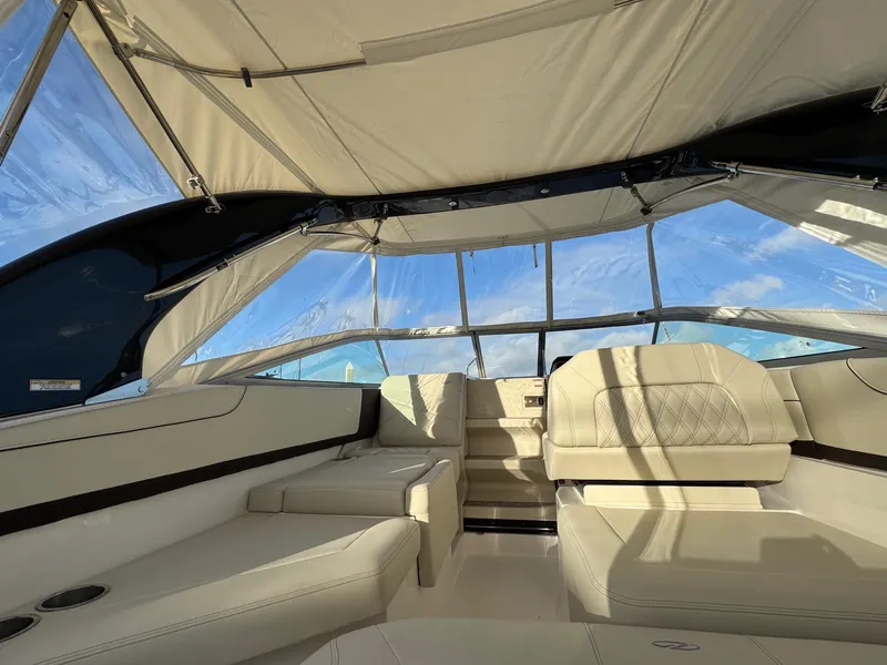 Slide: The Image of 2025 Regal 26 XO boat interior with beige seating and canopy under blue sky. - 23