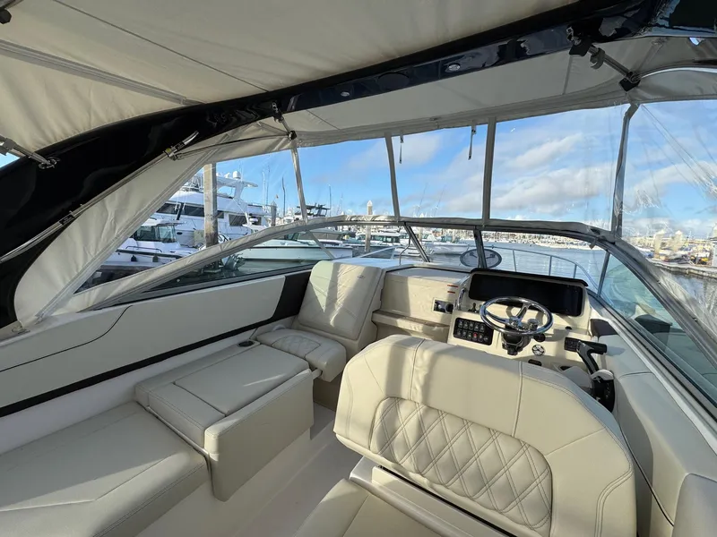 Slide: The Image of 2025 Regal 26 XO boat interior with luxurious seating and modern dashboard, docked at marina. - 24