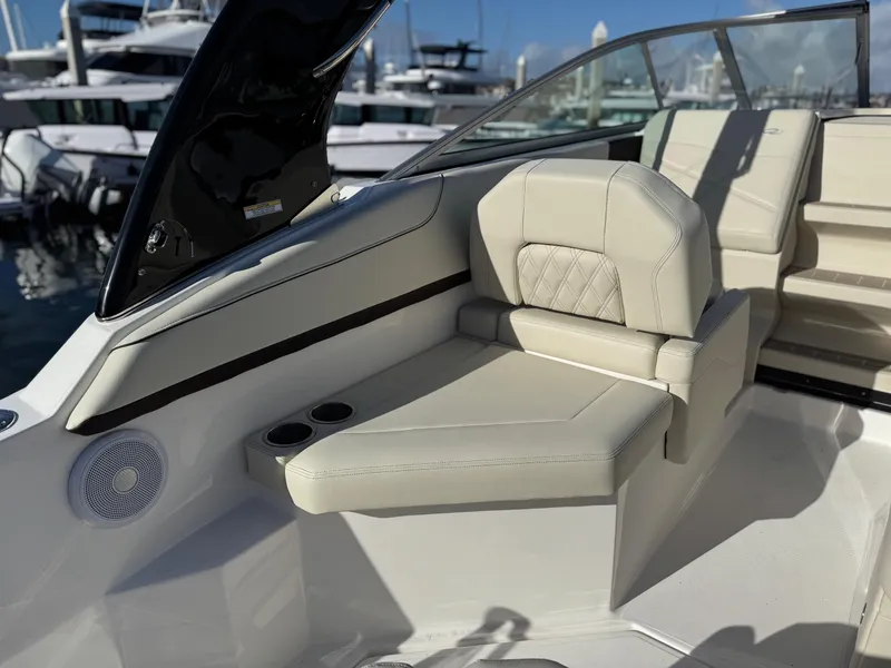 Slide: The Image of 2025 Regal 26 XO boat interior with beige seating and cup holders, docked at marina. - 29
