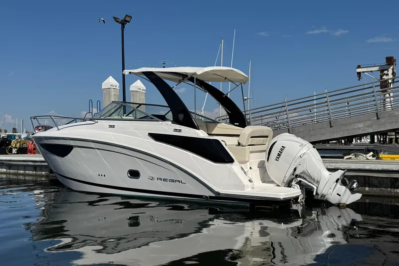 Slide: The Image of 2025 Regal 26 XO boat docked, featuring sleek design and Yamaha outboard motor. - 3