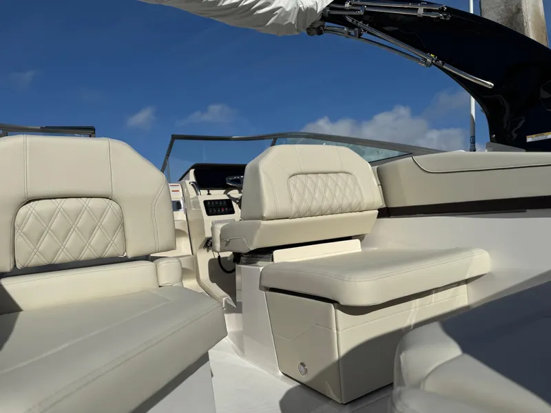 Slide: The Image of 2025 Regal 26 XO boat interior with beige seating and clear blue sky. - 30