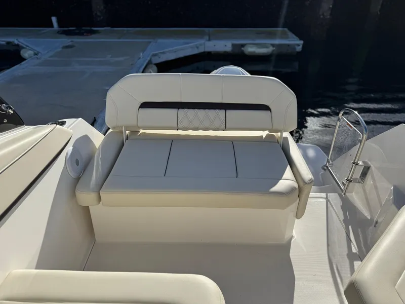 Slide: The Image of 2025 Regal 26 XO boat interior with white seating near dock. - 31