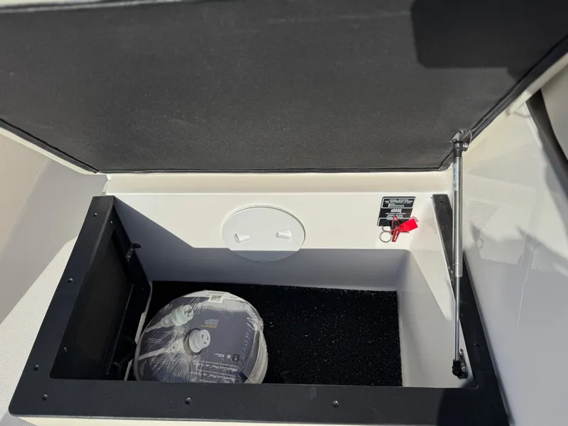 Slide: The Image of Storage compartment of 2025 Regal 26 XO boat, featuring safety equipment. - 34