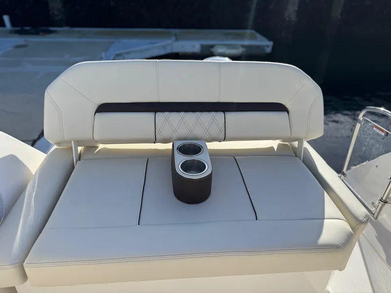 Slide: The Image of 2025 Regal 26 XO boat seating with cup holders, featuring elegant white upholstery. - 39