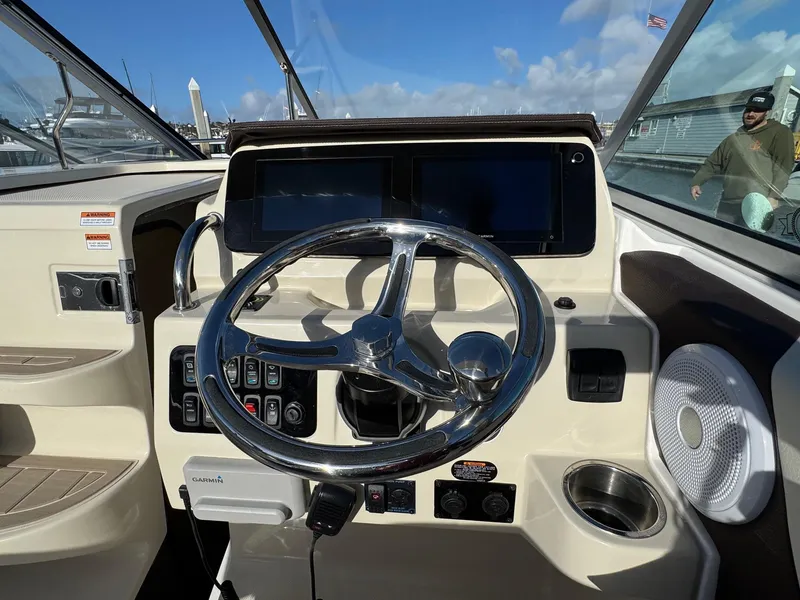 Slide: The Image of 2025 Regal 26 XO boat dashboard with steering wheel and control panel. - 46