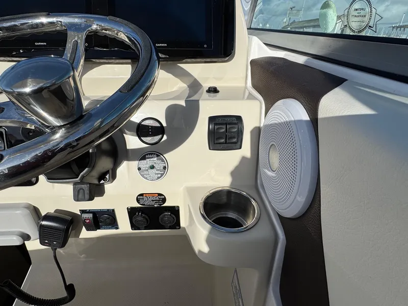 Slide: The Image of 2025 Regal 26 XO boat dashboard with steering wheel, controls, and speaker. - 49