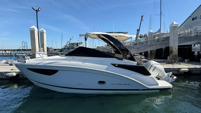 Slide: The Image of 2025 Regal 26 XO boat docked at marina under clear blue sky. - 5