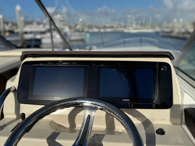 Slide: The Image of Helm of 2025 Regal 26 XO boat with dual Garmin displays and steering wheel. - 50