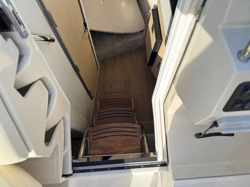 Slide: The Image of Interior view of 2025 Regal 26 XO boat, featuring wooden steps and modern design. - 53