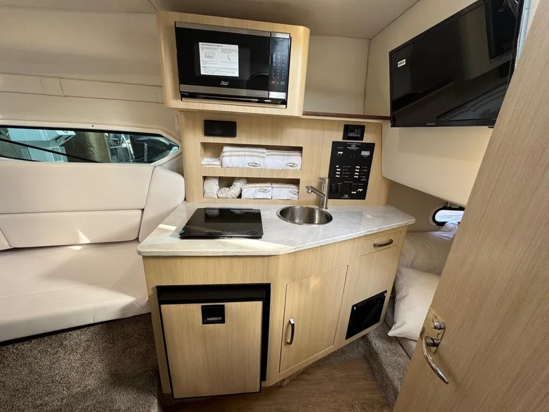 Slide: The Image of 2025 Regal 26 XO cabin interior with kitchenette, microwave, and modern amenities. - 57