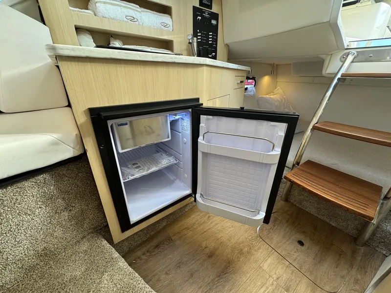 Slide: The Image of Compact fridge in 2025 Regal 26 XO boat interior, open door, wooden flooring, modern design. - 63