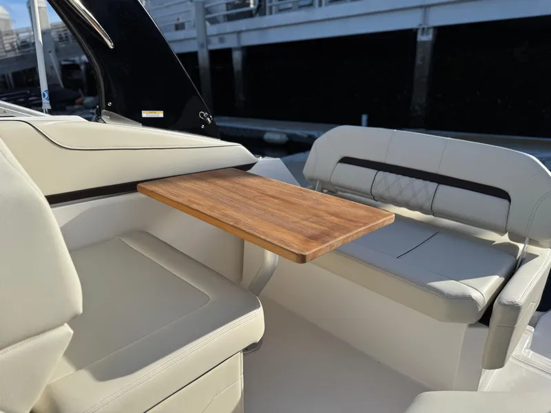 Slide: The Image of 2025 Regal 26 XO boat interior with wooden table and cushioned seating. - 78