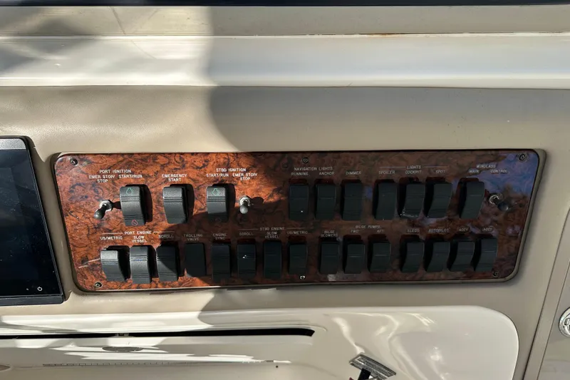 Slide: The Image of Control panel of a 2001 Sea Ray 540 Sundancer boat with various switches and toggles. - 36