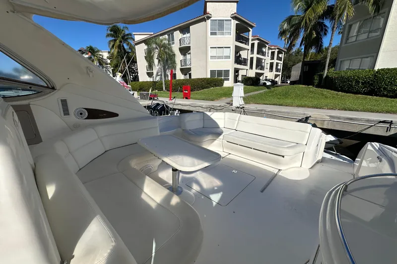 Slide: The Image of 2001 Sea Ray 540 Sundancer yacht interior with white seating and table, docked near buildings. - 45