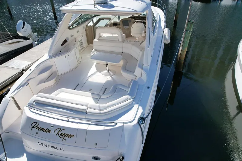 Slide: The Image of 2001 Sea Ray 540 Sundancer yacht docked, featuring spacious white seating and sleek design. - 72