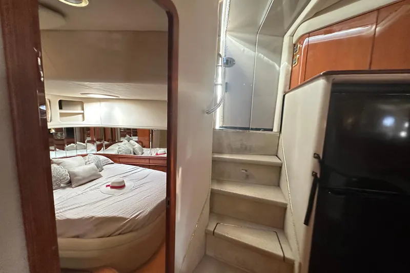 Slide: The Image of Interior of 2001 Sea Ray 540 Sundancer yacht, featuring a cozy bedroom and staircase. - 9