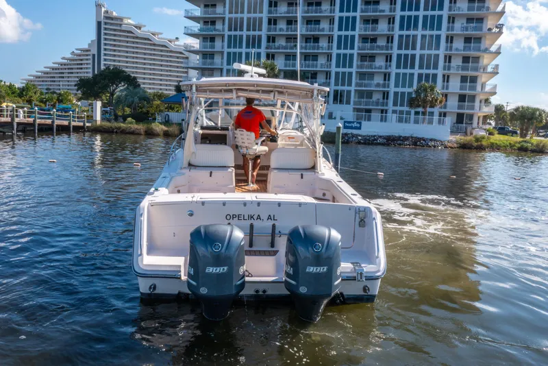 Slide: The Image of 2005 Grady-White Express 330 boat on water near modern buildings. - 10