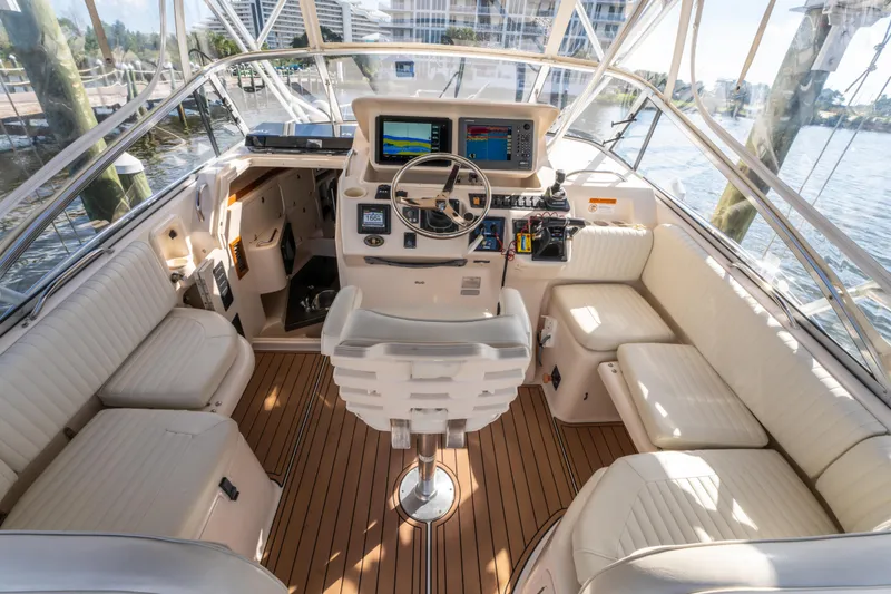 Slide: The Image of 2005 Grady-White Express 330 boat cockpit with modern navigation equipment and comfortable seating. - 14