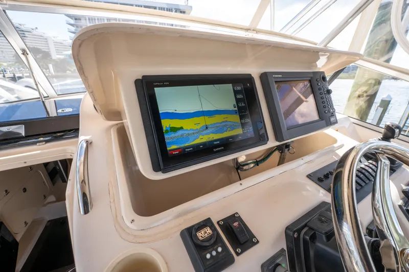Slide: The Image of 2005 Grady-White Express 330 helm with navigation screens and steering wheel. - 17