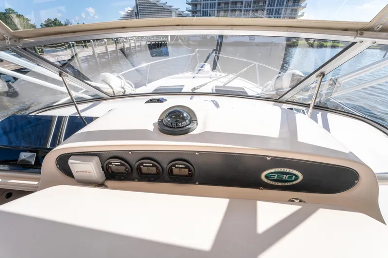 Slide: The Image of 2005 Grady-White Express 330 boat dashboard with compass and controls. - 22