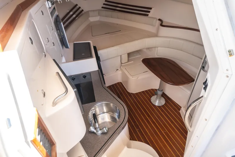 Slide: The Image of 2005 Grady-White Express 330 cabin interior with kitchenette and seating area. - 26