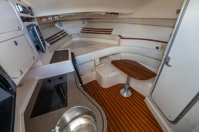 Slide: The Image of 2005 Grady-White Express 330 cabin interior with kitchenette and seating area. - 27