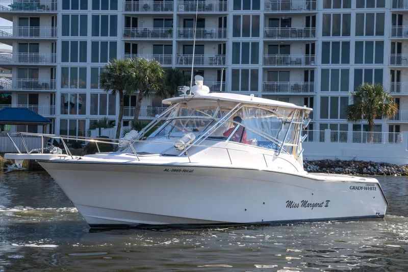 Slide: The Image of 2005 Grady-White Express 330 boat on water near modern apartment building. - 3