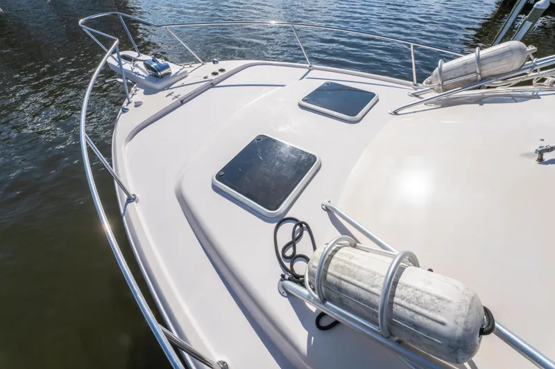 Slide: The Image of 2005 Grady-White Express 330 boat deck with hatches and railing on water. - 34