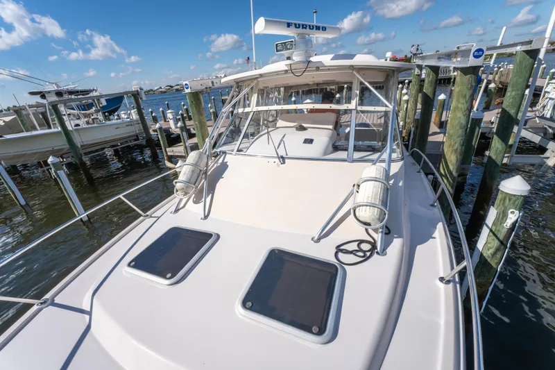 Slide: The Image of 2005 Grady-White Express 330 boat docked at marina under clear blue sky. - 35