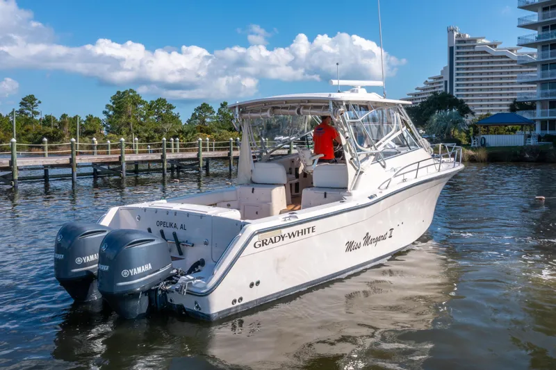 Slide: The Image of 2005 Grady-White Express 330 boat on water with Yamaha engines, dock and buildings in background. - 4