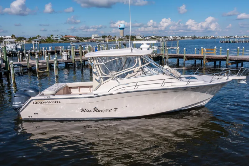 Slide: The Image of 2005 Grady-White Express 330 boat docked in a marina under a clear blue sky. - 6