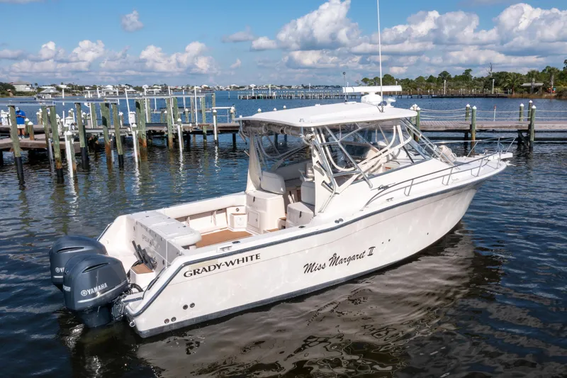 Slide: The Image of 2005 Grady-White Express 330 boat docked on calm waters under a blue sky. - 7