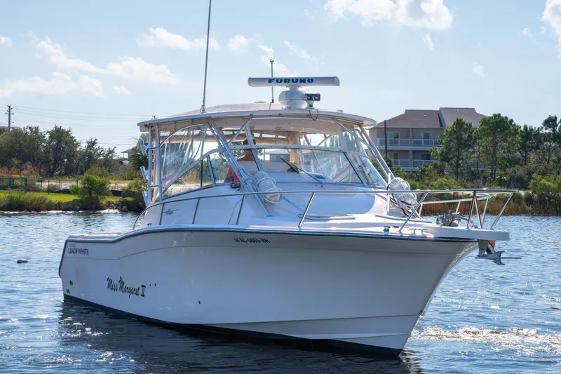 Slide: The Image of 2005 Grady-White Express 330 boat on water, sunny day, trees and buildings in background. - 9