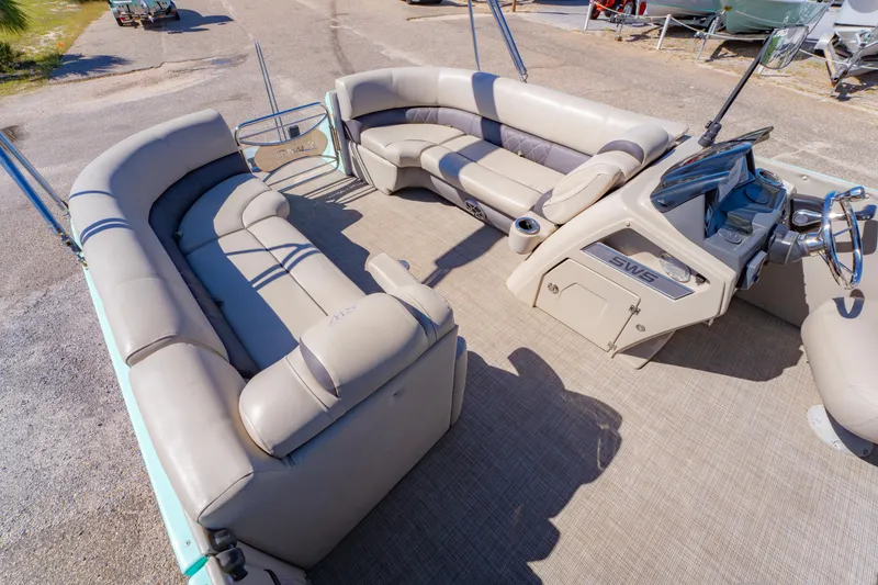 Slide: The Image of 2021 Silver Wave 2410 SW5 JS pontoon boat interior with beige seating and steering console. - 21