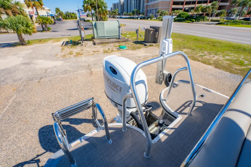 Slide: The Image of 2021 Silver Wave 2410 SW5 JS boat with Suzuki outboard motor, parked near palm trees. - 27