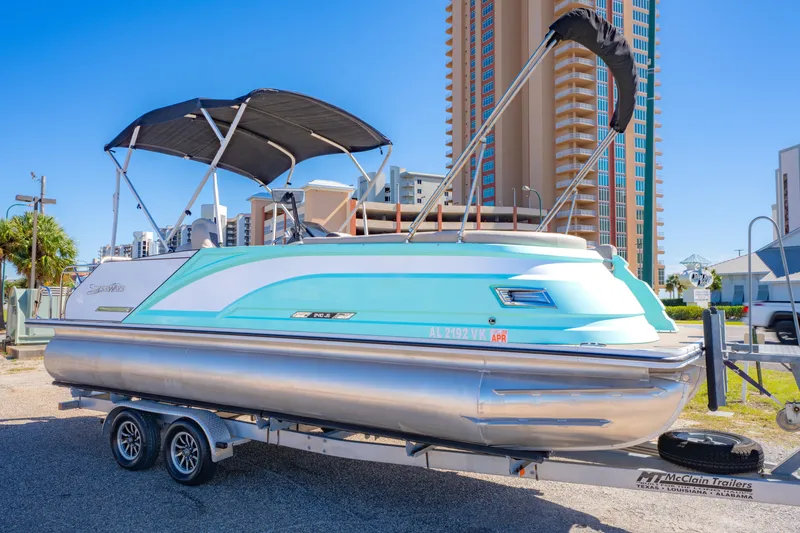 Slide: The Image of 2021 Silver Wave 2410 SW5 JS pontoon boat on trailer, urban background. - 4