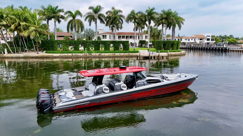 Slide: The Image of 2022 Nor-Tech 50 Sport boat with red accents on a scenic waterfront. - 12