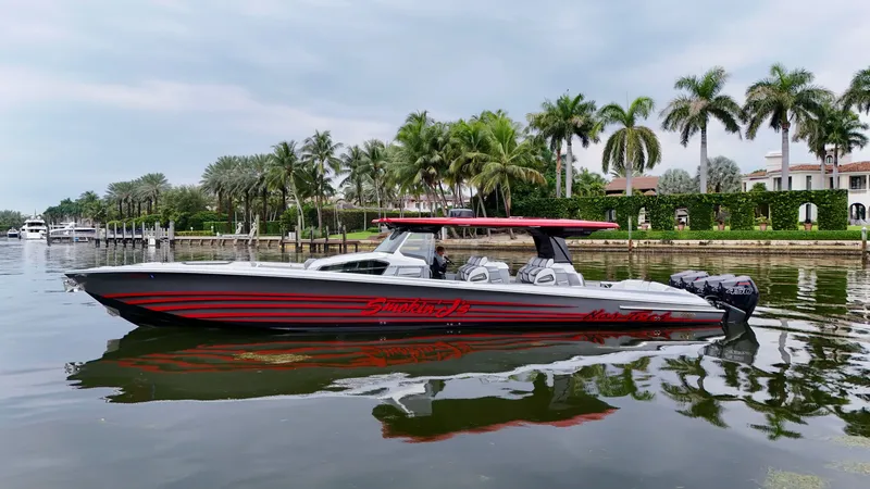Slide: The Image of 2022 Nor-Tech 50 Sport boat on calm water, surrounded by palm trees and luxury homes. - 14
