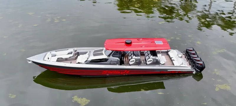 Slide: The Image of 2022 Nor-Tech 50 Sport boat with red roof and multiple outboard engines on calm water. - 18