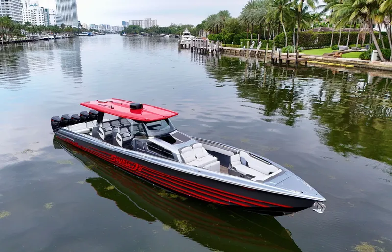 Slide: The Image of 2022 Nor-Tech 50 Sport boat with red accents on a calm waterway. - 2