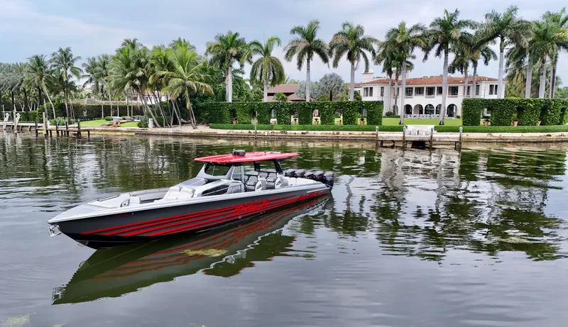 Slide: The Image of 2022 Nor-Tech 50 Sport boat on water, luxury waterfront mansion and palm trees in background. - 21