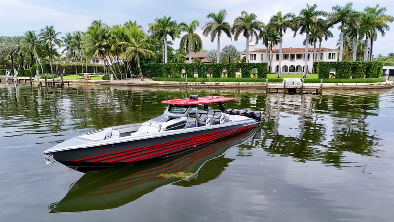 Slide: The Image of 2022 Nor-Tech 50 Sport boat on calm water near a luxurious waterfront estate. - 22
