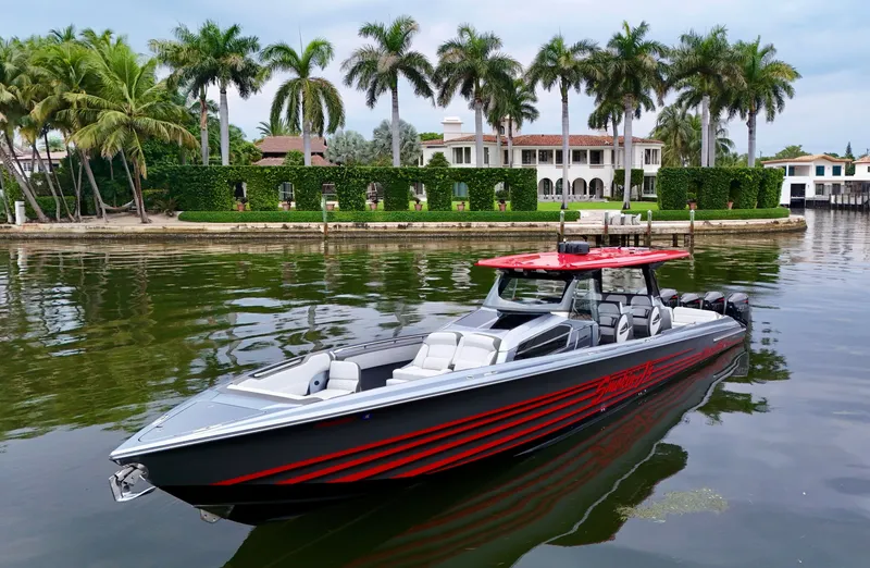 Slide: The Image of 2022 Nor-Tech 50 Sport boat on calm water, with luxury waterfront mansion and palm trees in background. - 23