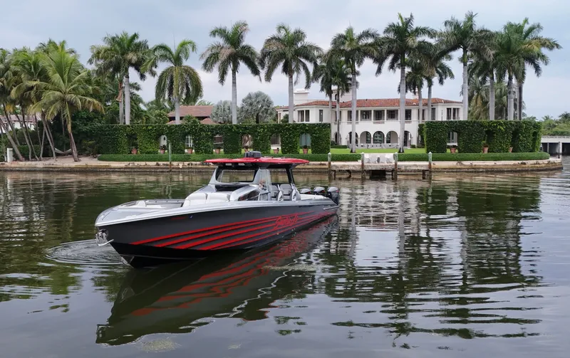 Slide: The Image of 2022 Nor-Tech 50 Sport boat cruising near luxury waterfront mansion with palm trees. - 26