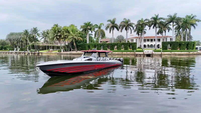Slide: The Image of 2022 Nor-Tech 50 Sport boat on calm water, with palm trees and luxury mansion in background. - 27